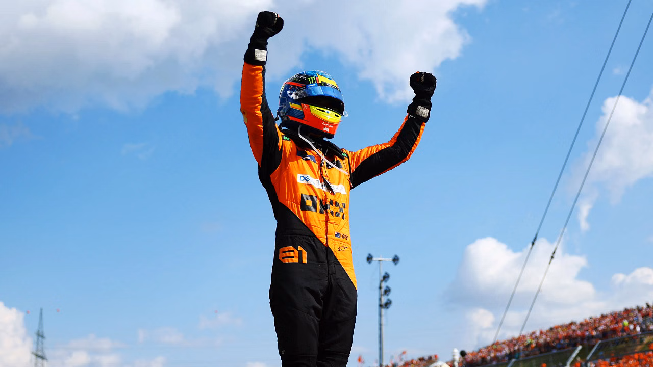 A driver celebrating a win, arms raised